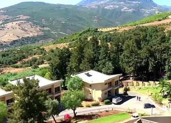 Vue panoramique du complexe thermal de Hammam Mrigha, à Aïn Defla, niché au cœur d'un paysage verdoyant entouré de montagnes et de forêts.