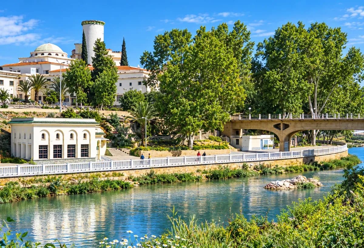 Hammam Bouhanifia, dans la wilaya de Mascara, avec ses bâtiments thermaux, sa rivière et sa végétation verdoyante.